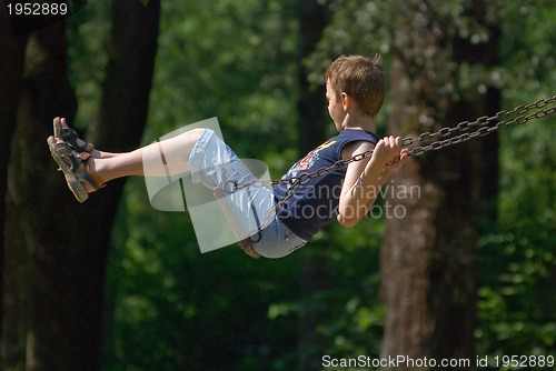 Image of boy swinging in park