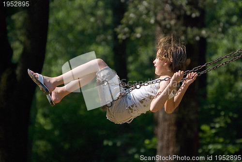 Image of happy girl swinging 