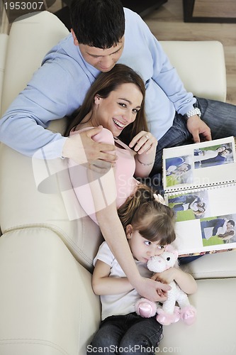 Image of happy family looking photos at home