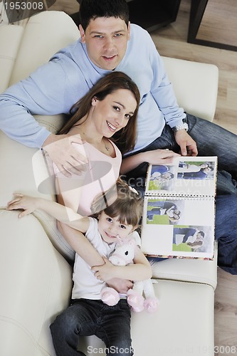 Image of happy family looking photos at home