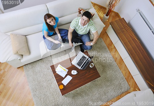 Image of young couple working on laptop at home