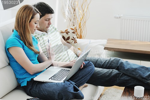 Image of young couple working on laptop at home