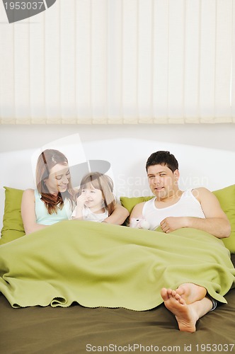 Image of happy family relaxing in bed
