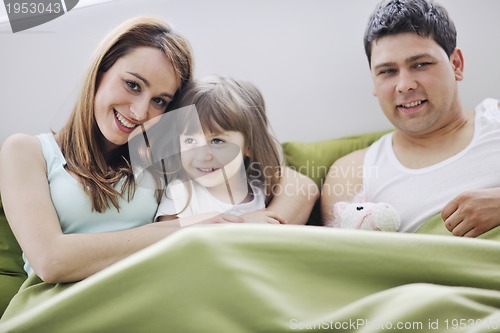 Image of happy family relaxing in bed