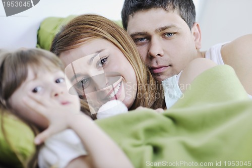 Image of happy family relaxing in bed