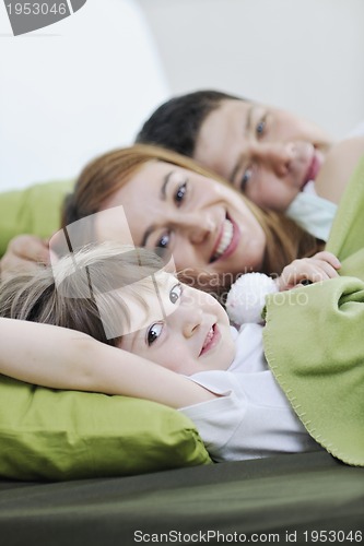 Image of happy family relaxing in bed