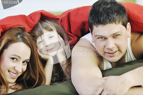 Image of happy family relaxing in bed