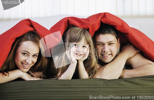Image of happy family relaxing in bed