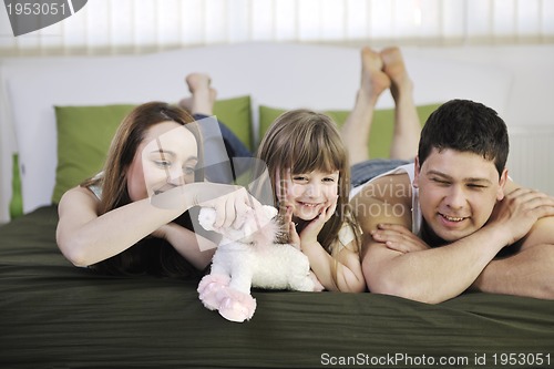 Image of happy family relaxing in bed