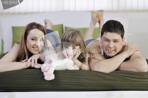 Image of happy family relaxing in bed