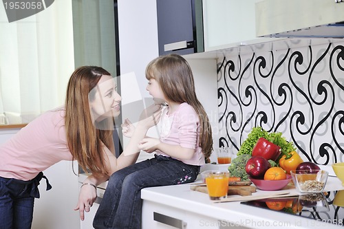 Image of happy daughter and mom in kitchen