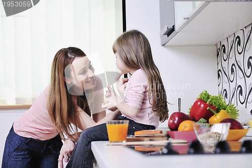 Image of happy daughter and mom in kitchen