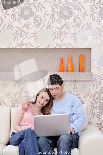 Image of young couple working on laptop at home