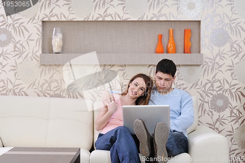 Image of young couple working on laptop at home