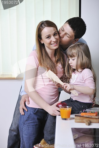 Image of happy young family in kitchen