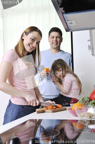 Image of happy young family in kitchen