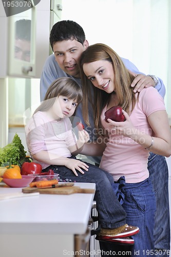 Image of happy young family in kitchen