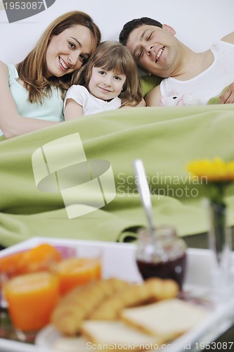 Image of happy young family eat breakfast in bed