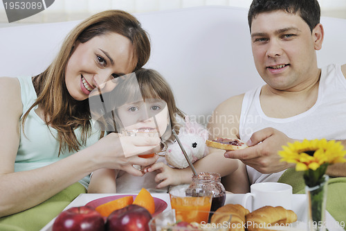 Image of happy young family eat breakfast in bed