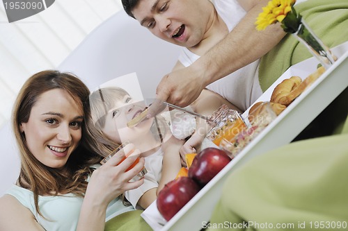 Image of happy young family eat breakfast in bed