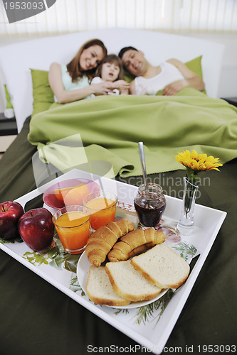 Image of happy young family eat breakfast in bed