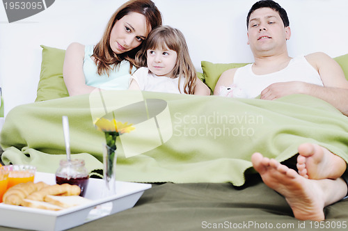 Image of happy young family eat breakfast in bed