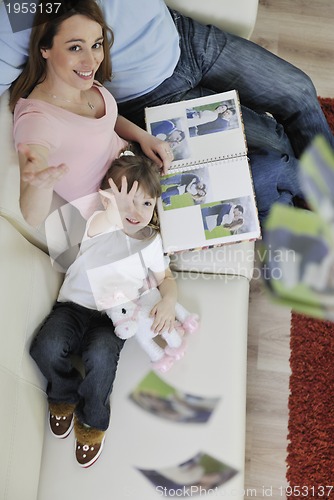 Image of happy family looking photos at home