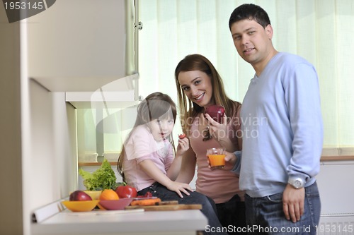 Image of happy young family in kitchen