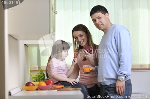 Image of happy young family in kitchen