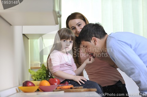 Image of happy young family in kitchen