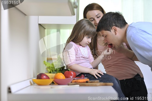 Image of happy young family in kitchen