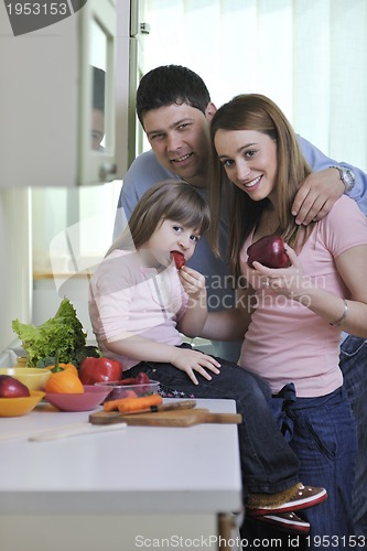 Image of happy young family in kitchen