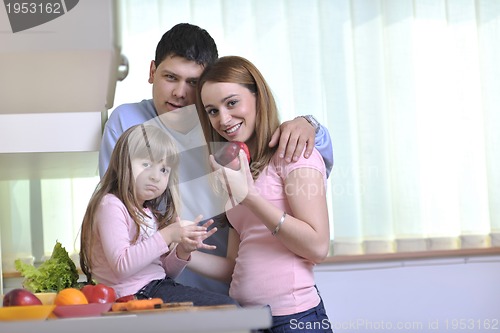 Image of happy young family in kitchen