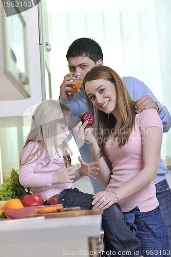Image of happy young family in kitchen