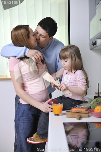 Image of happy young family in kitchen