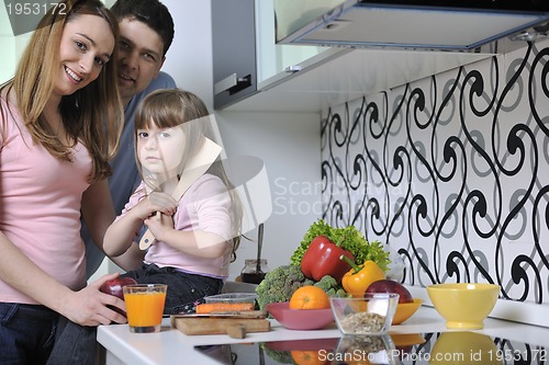 Image of happy young family in kitchen