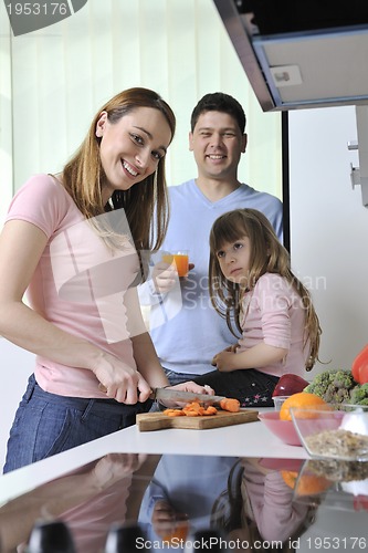 Image of happy young family in kitchen