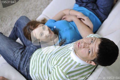 Image of couple relax at home on sofa in living room