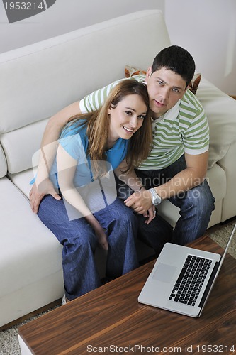 Image of young couple working on laptop at home