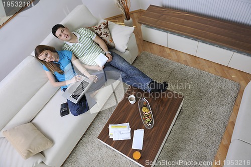 Image of young couple working on laptop at home