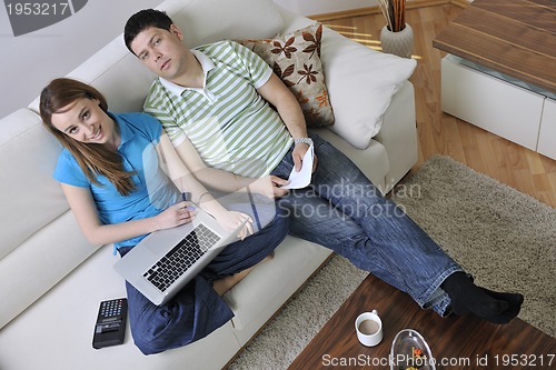 Image of young couple working on laptop at home