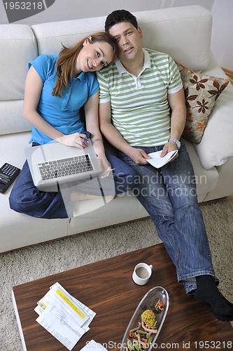 Image of young couple working on laptop at home