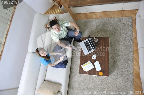 Image of young couple working on laptop at home