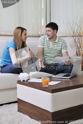 Image of young couple working on laptop at home