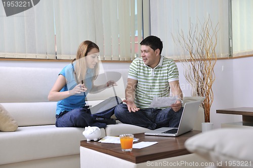 Image of young couple working on laptop at home