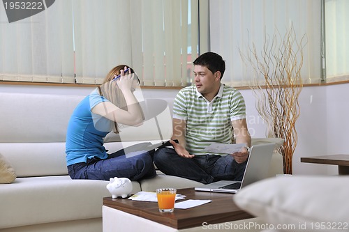 Image of young couple working on laptop at home