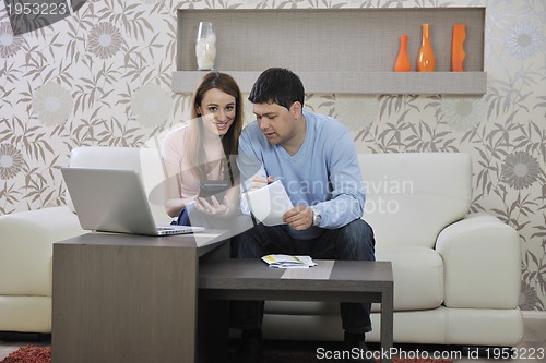 Image of young couple working on laptop at home