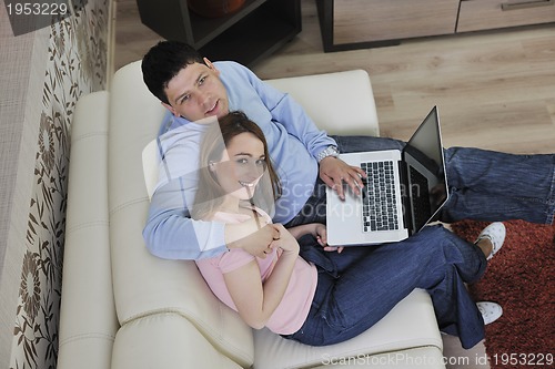 Image of young couple working on laptop at home