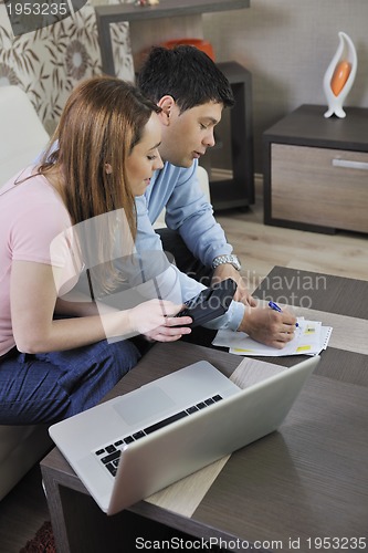 Image of young couple working on laptop at home