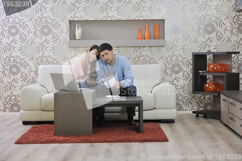 Image of young couple working on laptop at home